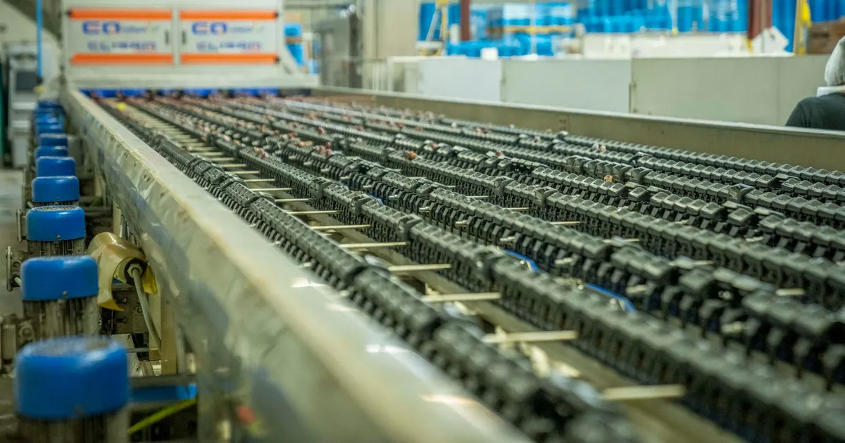 Chain conveyor line running on a supporting frame inside a factory hall, an example of automation line frames built in volume