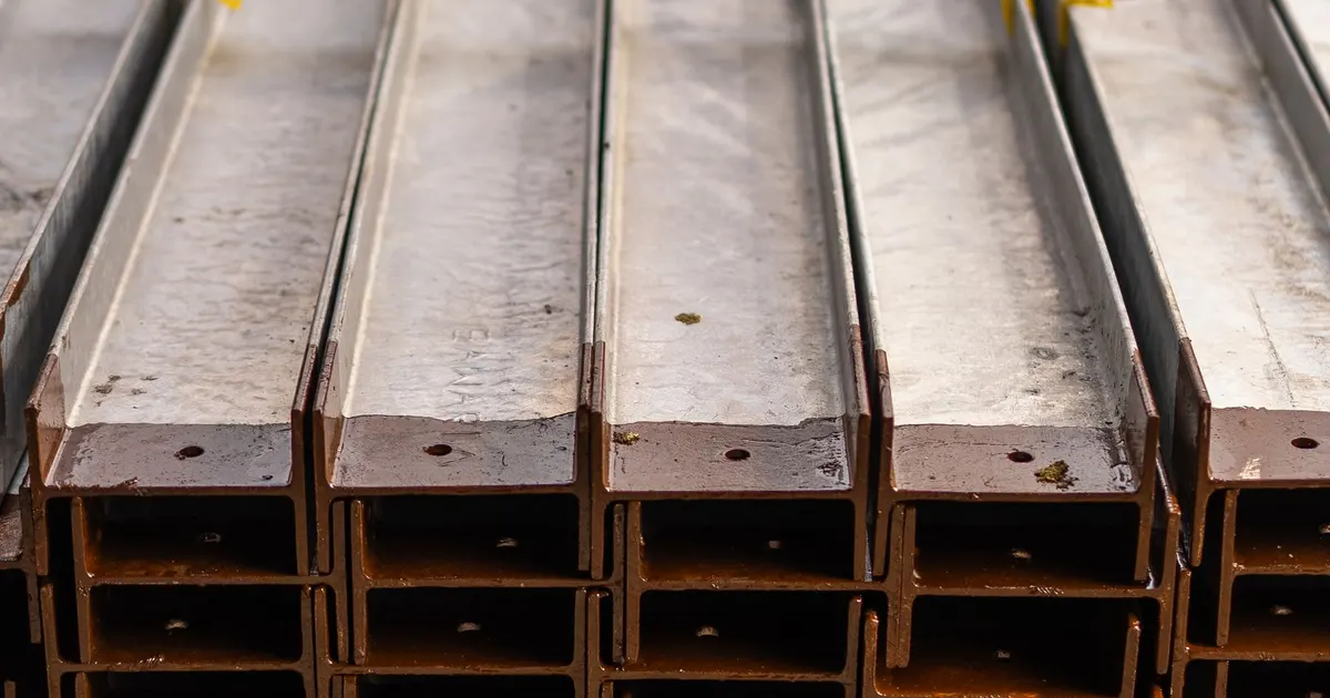 Stacked structural steel sections in a fabrication yard, the kind of S355 material used for welded machine frames