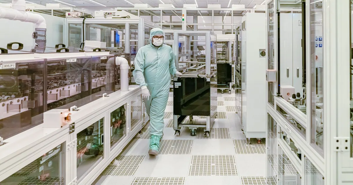 Cleanroom hall with enclosed equipment line and a technician in a protective suit, the environment in which a semiconductor equipment frame operates